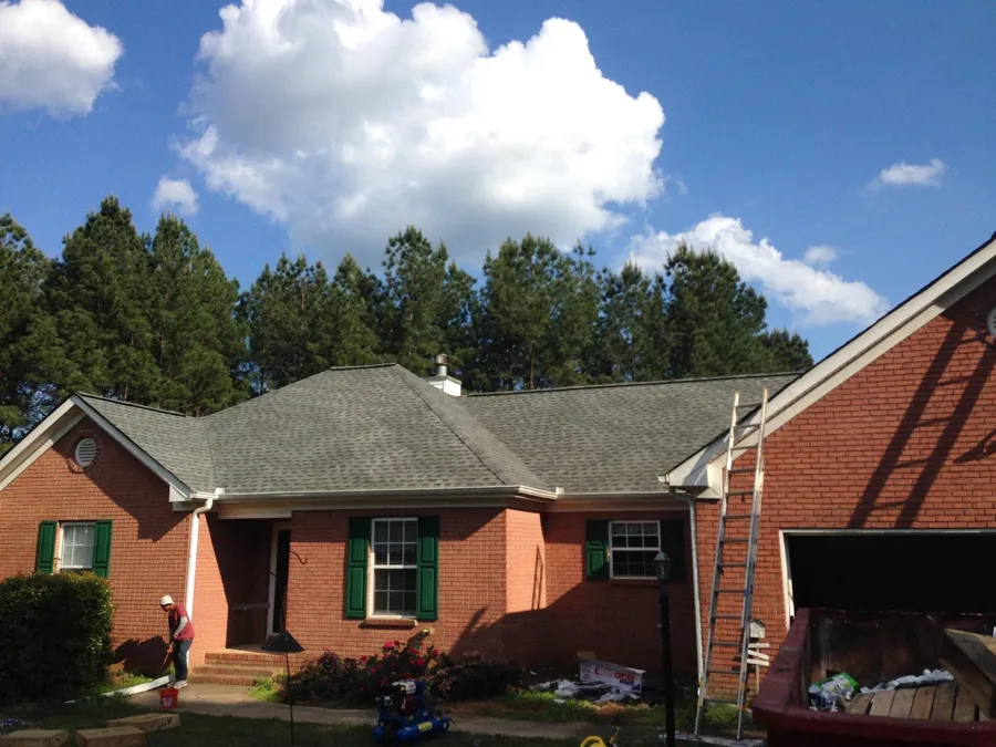 New architectural shingle roof going on a brick ranch home, ladder up and crew finishing
