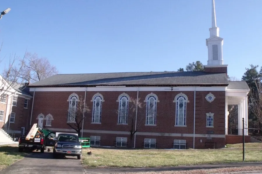 New roof on a brick church with a white steeple